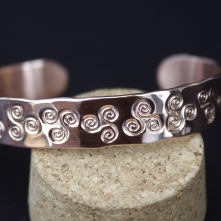 Gros plan du bracelet cuivre martelé Triskell artisanal avec motifs celtiques poinçonnés à la main.
