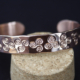 Gros plan du bracelet cuivre martelé Triskell artisanal avec motifs celtiques poinçonnés à la main.