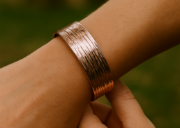 Bracelet cuivre martelé à stries intenses porté au poignet d’une femme, en extérieur.