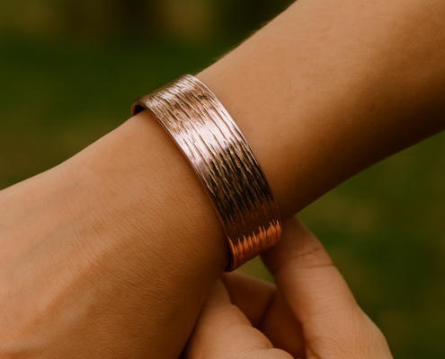 Bracelet cuivre martelé à stries intenses porté au poignet d’une femme, en extérieur.