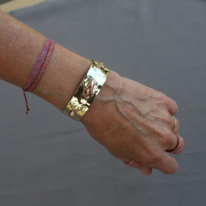 Bracelet laiton cuivre Origine porté au poignet, montrant ses reflets et ses inclusions de cuivre martelé.