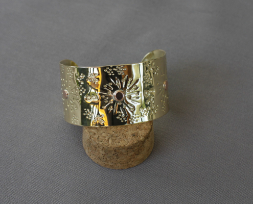 Bracelet manchette en laiton martelé 25 mm posé sur socle, trois rivets cuivre soudés à l’argent