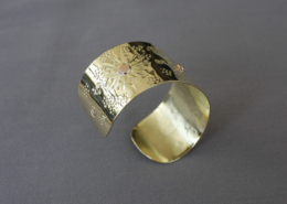Détail du bracelet en laiton martelé soleil avec motifs poinçonnés et rivets cuivre