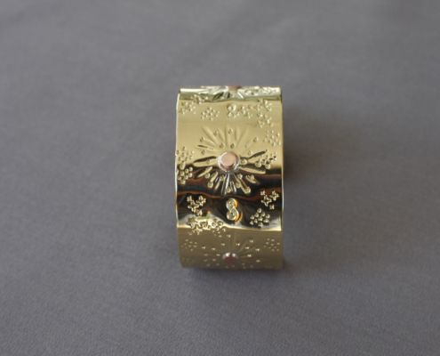 Bracelet en laiton martelé soleil vue frontale avec symbole infini et rivet cuivre central