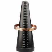 Bracelet manchette en cuivre martelé positionné sur un triboulet gradué indiquant une taille 19 cm
